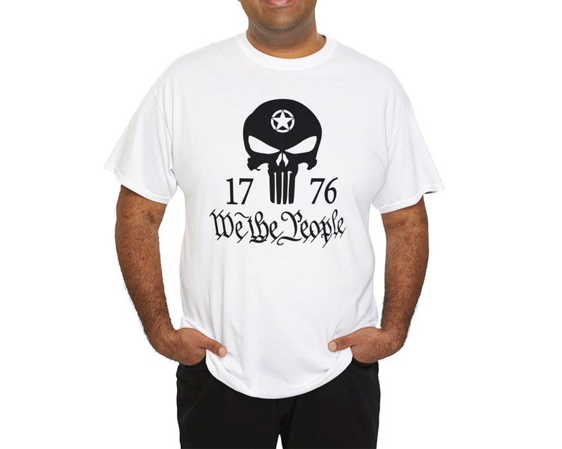 Op de afbeelding: Wit T-shirt met een zwarte schedel afbeelding en de tekst "1776 We the People".
