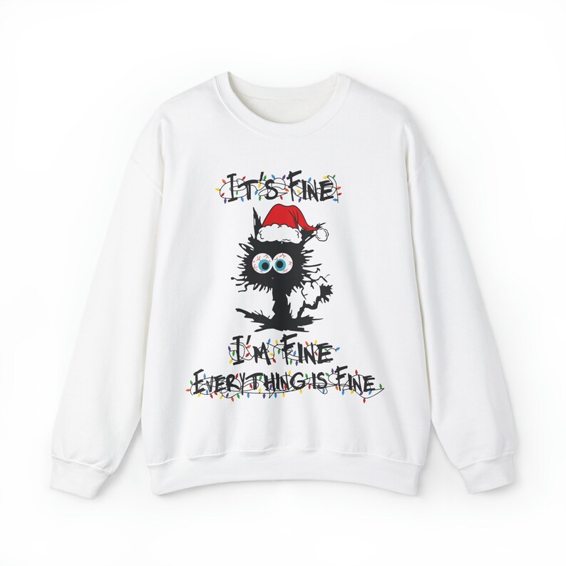 May include: White long-sleeved sweatshirt with a black cat wearing a Santa hat and Christmas lights. The text "It's Fine I'm Fine Everything is Fine" is printed on the sweatshirt.