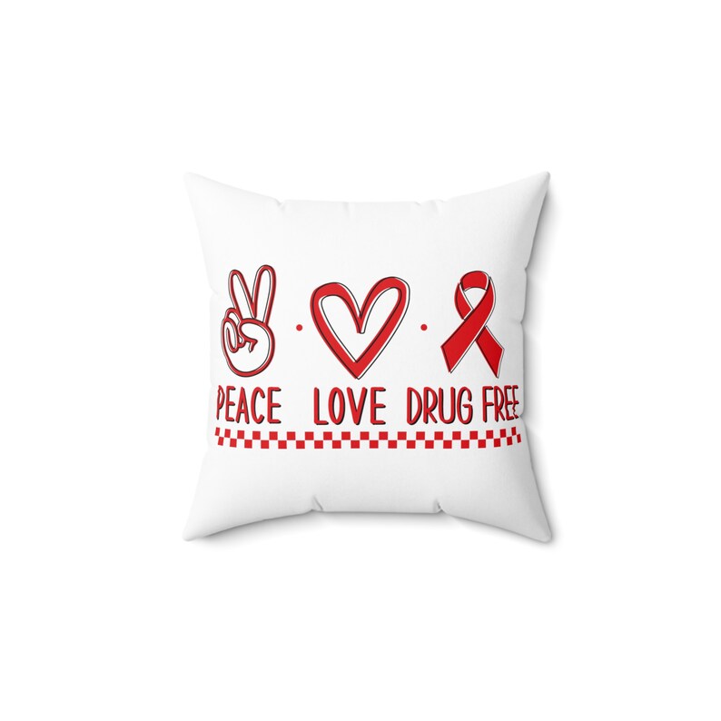 May include: White pillow with red peace sign, heart, and ribbon with the text "Peace Love Drug Free" and a red and white checkered line.