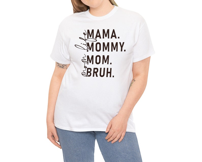May include: White t-shirt with black text that reads "Little Mama. Mommy. Mom.  Bruh."
