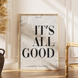 Può includere: Una stampa artistica da parete rettangolare in una cornice di legno chiaro con uno sfondo in stile giornale e il testo nero in grassetto "Reminder", "IT'S ALL GOOD" ed "Everything is figureoutable" in un carattere sans-serif.