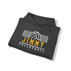 May include: A dark gray hooded sweatshirt with a white volleyball and net graphic. The text "JIMMY VOLLEYBALL" is in yellow.