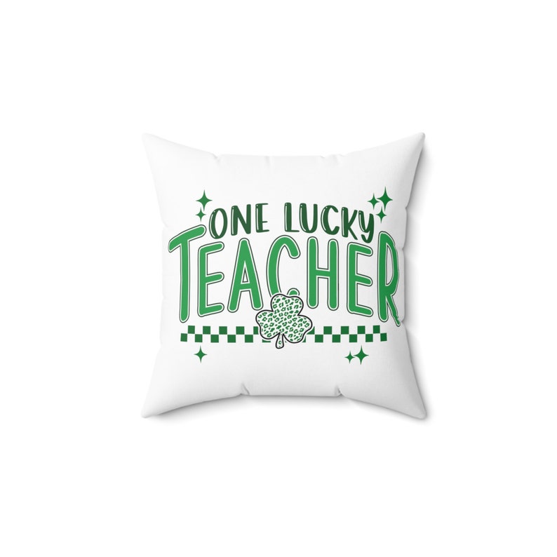 Puede incluir: Almohada blanca con texto verde que dice "One Lucky Teacher" con un tr&eacute;bol verde debajo del texto.