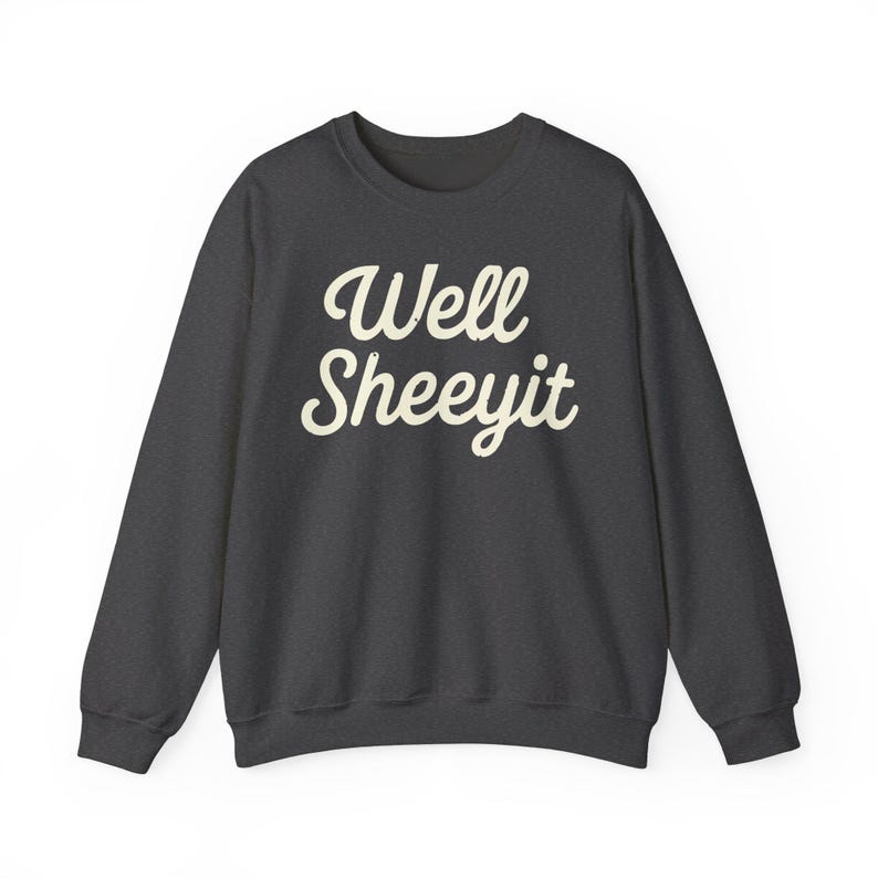 K&ouml;nnte beinhalten: Dunkelgraues Sweatshirt mit dem Schriftzug "Well Sheeyit" in wei&szlig;er, kursiver Schrift. Das Sweatshirt hat einen Rundhalsausschnitt und lange &Auml;rmel. Der Text ist mittig auf der Brust platziert.