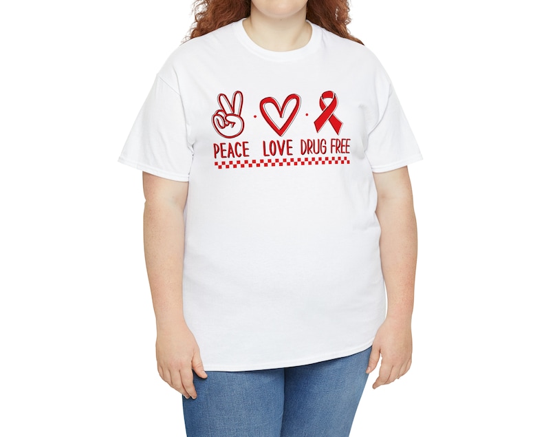 May include: White t-shirt with a red peace sign, heart, and ribbon with the text "Peace Love Drug Free".