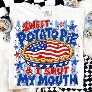May include: White t-shirt with a graphic design featuring the text "Sweet Potato Pie & I Shut My Mouth." The design includes a pie with an American flag motif, surrounded by blue and red stars.
