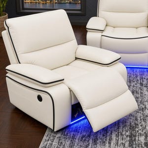 May include: A white leather recliner chair featuring black piping along the edges and a built-in blue LED light strip at the base. The chair has a padded backrest, armrests, and an extended footrest, with a circular control button on the side.