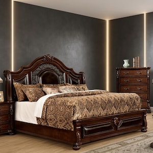 May include: A dark wood bed frame featuring an arched headboard with dark brown leather upholstery and intricate carved details. The bed is dressed in a brown patterned comforter and matching pillows, accompanied by a matching five-drawer chest.