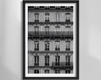 May include: A black and white framed wall art print depicting the facade of a multi-story building with symmetrical windows, white shutters, and ornate wrought iron balconies. The architectural structure features repeating rows of glass panes.