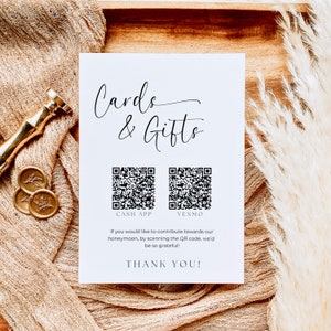 K&ouml;nnte beinhalten: Eine wei&szlig;e Karte mit schwarzem Text, der "Cards & Gifts" lautet. Unter dem Text sind zwei schwarz-wei&szlig;e QR-Codes abgebildet, die mit "Cash App" und "Venmo" beschriftet sind. Der Text unter den QR-Codes lautet: "Wenn Sie zu unserer Hochzeitsreise beitragen m&ouml;chten, scannen Sie den QR-Code. Wir w&auml;ren Ihnen sehr dankbar! Vielen Dank!"