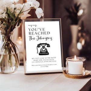 a vase with flowers and a sign on a table