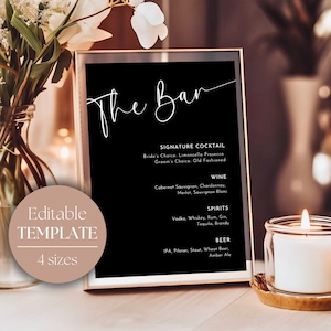 May include: A black sign with white text that reads "The Bar" and lists drink options for a wedding or event. The sign is in a black frame and is sitting on a table with a candle.