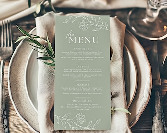 Puede incluir: Una tarjeta de menú verde con un diseño floral y texto blanco. El menú incluye aperitivos, platos principales, postre y bebidas. Los artículos del menú son: Brochetas Caprese, Pastel de Cangrejo Niebla, Filete Mignon, Salmón a la parrilla, Pastel de Boda, Pastel de Queso de Limón, Lapis de Chile, Sauvignon Blanc Black Cottage Marlborough, Té y Café.