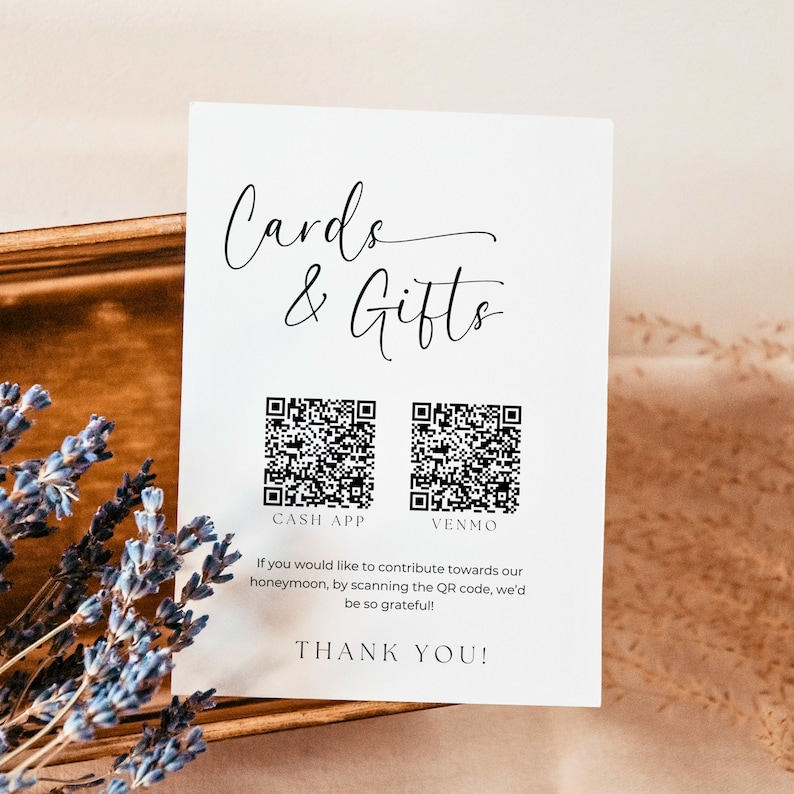 K&ouml;nnte beinhalten: Eine wei&szlig;e Karte mit dem Text "Cards & Gifts" in schwarzer Kursivschrift. Unter dem Text befinden sich zwei schwarz-wei&szlig;e QR-Codes, beschriftet mit "Cash App" und "Venmo". Unter den QR-Codes steht der Text "Wenn Sie zu unseren Flitterwochen beitragen m&ouml;chten, scannen Sie den QR-Code. Wir w&auml;ren Ihnen sehr dankbar!" Der Text "Vielen Dank!" befindet sich am unteren Rand der Karte.
