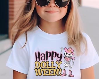 May include: White t-shirt with the text "Happy DOLLY WEEN!" in pink and yellow. The shirt features a cartoon skeleton wearing a pink cowboy hat and boots. The girl is wearing a pink cap and sunglasses.