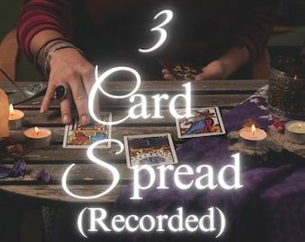 May include: A three-card tarot spread with candles and incense on a wooden table. The cards are face up and show the Queen of Wands, the Tower, and the World. The text "3 Card Spread (Recorded)" is superimposed on the image.