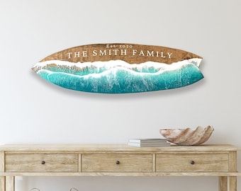 May include: A wooden surfboard wall decor with a blue and white wave design. The surfboard has the text "Est. 2010 The Smith Family" written on it.