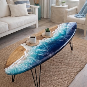 May include: Oval coffee table with a wood and resin design. The table features a wood grain surface on one side and a blue and white ocean wave design on the other. It has black metal hairpin legs.