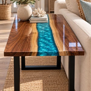 May include: A rectangular coffee table featuring a natural wood slab with a live edge and a central, translucent, rippled turquoise resin river inlay. The table is supported by a black metal frame with four legs and a smooth, glossy finish.