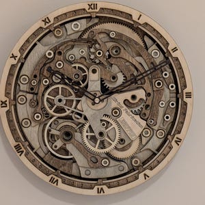 Könnte beinhalten: Wanduhr aus Holz mit detailliertem Zahnradmechanismus-Design. Das Zifferblatt der Uhr zeigt römische Ziffern und komplizierte Schichten aus Holzrädern, wodurch eine Steampunk-Ästhetik entsteht. Die Zeiger der Uhr sind schwarz.