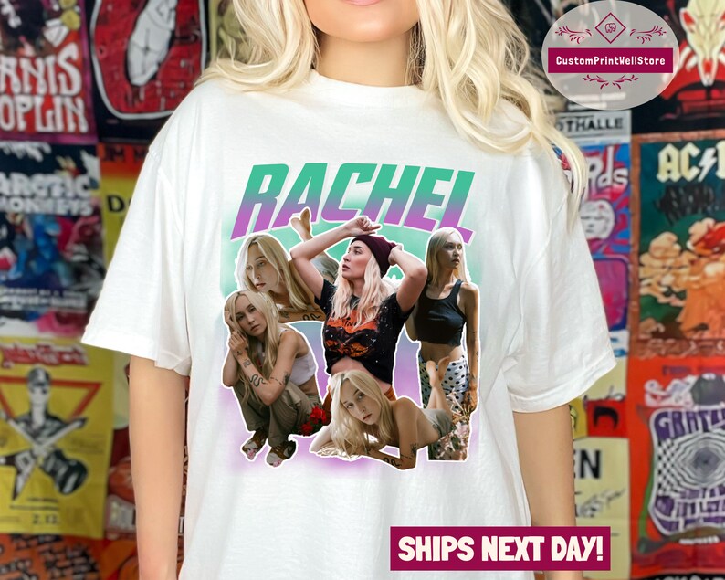 May include: White t-shirt featuring a graphic print of the name "Rachel" in a green and purple gradient. The graphic also includes four women with various hairstyles and outfits.