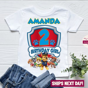 May include: White t-shirt with a red and blue Paw Patrol logo, the number 2, and the text "Amanda" and "Birthday Girl".