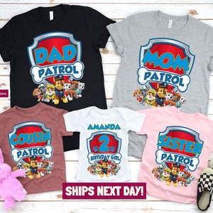 May include: Five t-shirts featuring the Paw Patrol characters. The shirts say "Dad Patrol", "Mom Patrol", "Cousin Patrol", "Sister Patrol", and "Amanda 2nd Birthday Girl".
