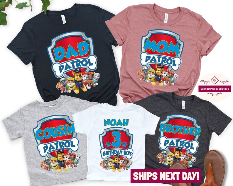 May include: Set of five t-shirts featuring the Paw Patrol characters. The shirts are in various colors, including gray, blue, pink, white, and black. The shirts have different text, including "Dad Patrol", "Mom Patrol", "Cousin Patrol", "Brother Patrol", and "Noah 3 Birthday Boy".