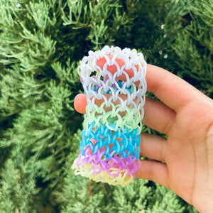 May include: A rainbow loom bracelet made with colorful rubber bands. The bracelet is made in a fishtail pattern and has a variety of colors, including purple, blue, green, and yellow.