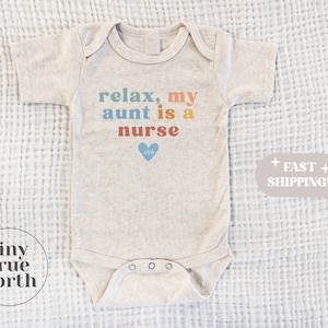 May include: A beige baby onesie with the text "relax, my aunt is a nurse" in rainbow colors with a blue heart and a heartbeat symbol.