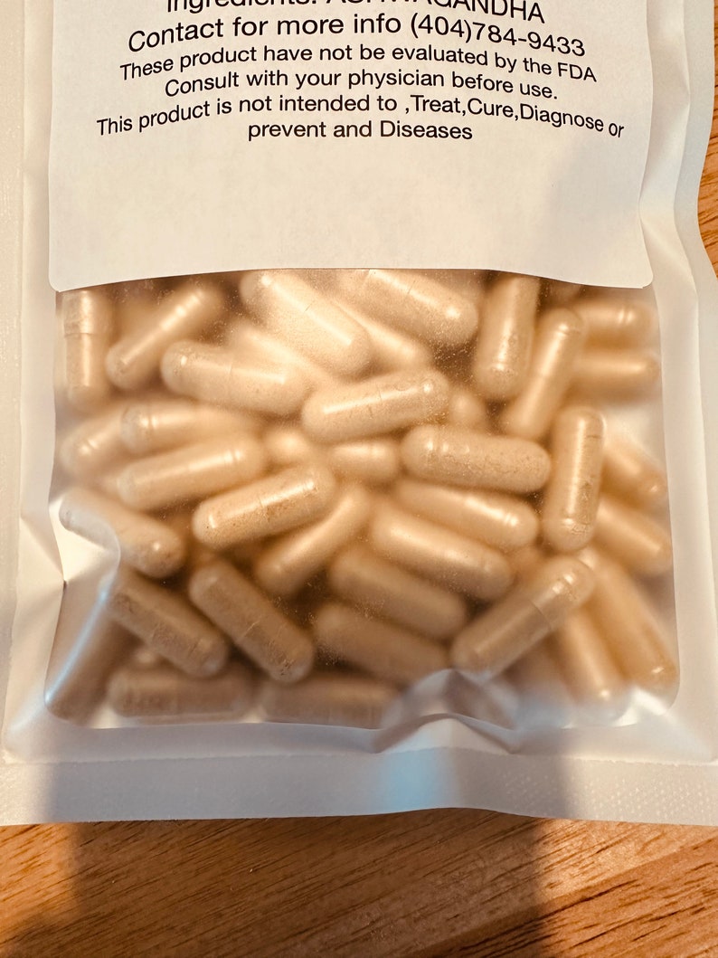 Peut inclure: Une image rapproch&eacute;e d'un sac en plastique transparent rempli d'une grande quantit&eacute; de capsules beiges. Le sac est scell&eacute; et porte une &eacute;tiquette blanche avec le texte "Contact for more info (404)784-9433 These product have not be evaluated by the FDA Consult with your physician before use. This product is not intended to, Treat, Cure, Diagnose or prevent and Diseases"