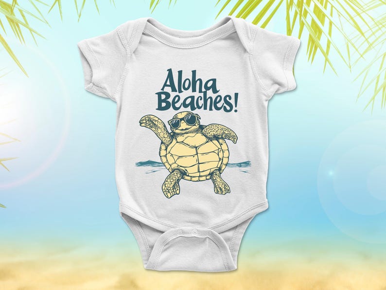 Pu&ograve; includere: Body da bambino bianco con la scritta "Aloha Beaches!" sopra una tartaruga dei cartoni animati con gli occhiali da sole. La tartaruga &egrave; gialla e verde, con acqua blu sullo sfondo. Il body ha maniche corte e chiusura a scatto.