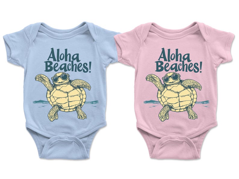 Pu&ograve; includere: Due body per neonati, uno azzurro chiaro e uno rosa, ciascuno con una tartaruga dei cartoni animati con occhiali da sole. Il testo "Aloha Beaches!" &egrave; stampato sopra la tartaruga. La tartaruga &egrave; gialla e beige.