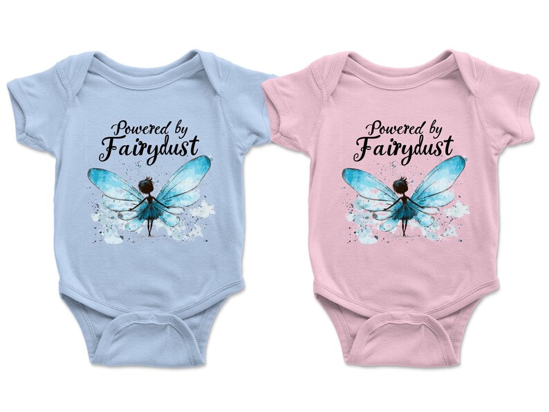 Puede incluir: Dos bodies de beb&eacute;, uno celeste y otro rosa, cada uno con el texto "Powered by Fairydust". Ambos presentan una ilustraci&oacute;n de acuarela de un hada con alas azules. Los bodies est&aacute;n dise&ntilde;ados para beb&eacute;s.