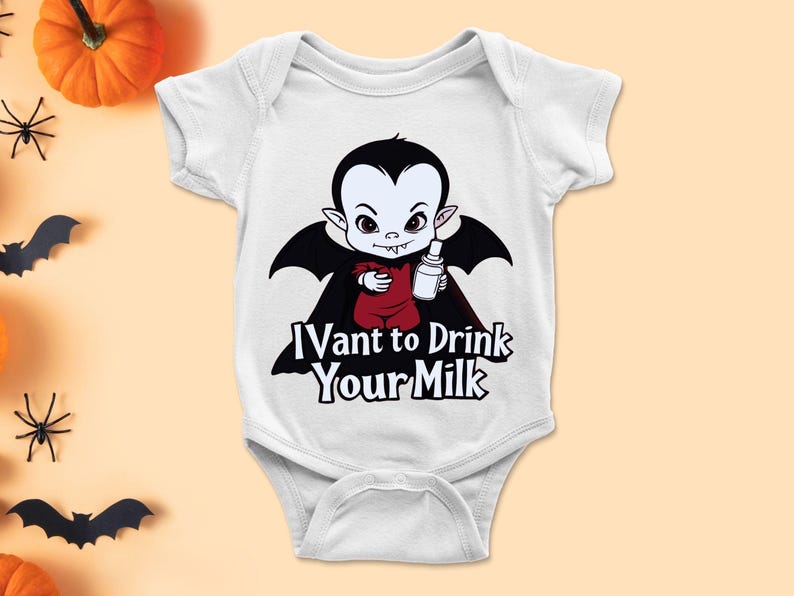 以下が含まれることがあります： 白いベビーボディスーツ。黒いマントを着て哺乳瓶を持った漫画の吸血鬼が描かれています。「I Vant to Drink Your Milk」の文字がプリントされています。ハロウィーンに最適です。
