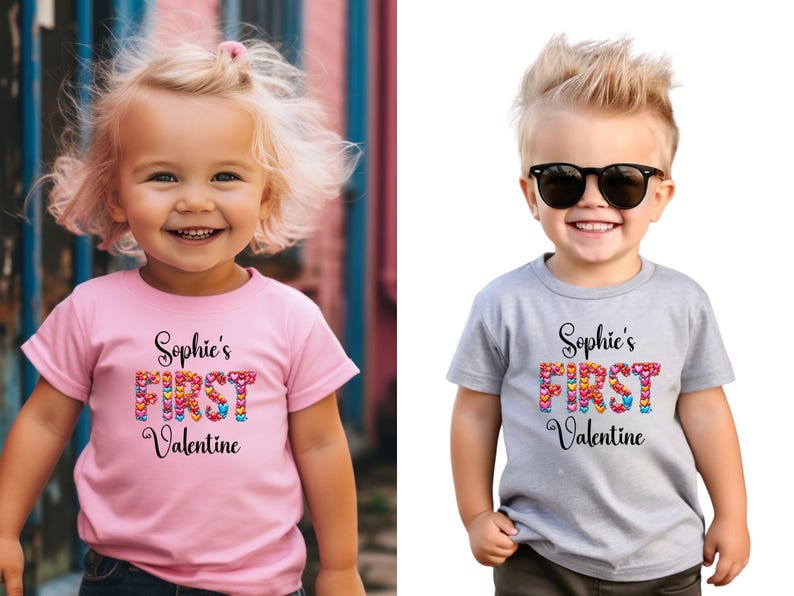 May include: Two children wearing t-shirts with the text "Sophie's FIRST Valentine". The text is in black script with the word "FIRST" in colorful heart shapes. One shirt is pink, the other is gray.