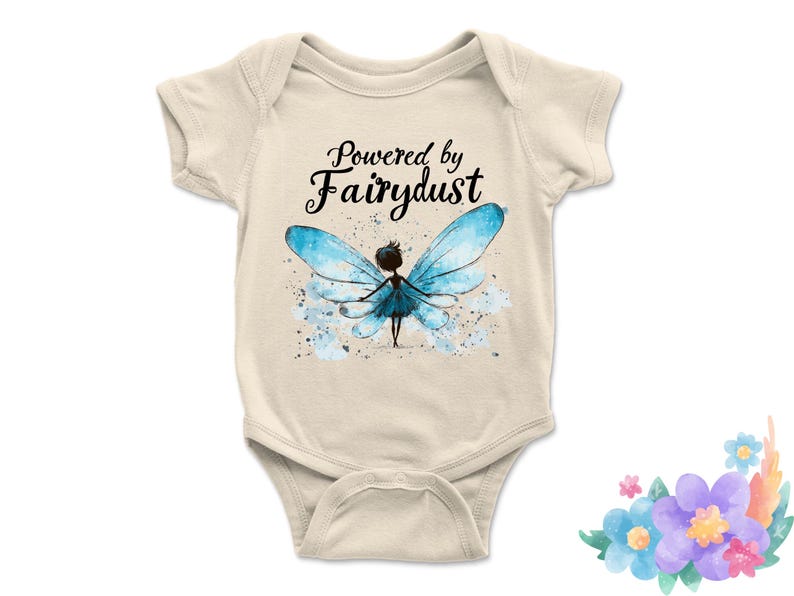 Puede incluir: Body de beb&eacute; color crema con el texto "Powered by Fairydust" en escritura negra. Ilustraci&oacute;n de acuarela de un hada con alas azules y salpicaduras de acuarela azules.