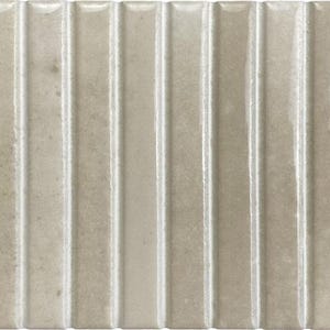 May include: A rectangular ceramic wall tile in a light beige color with a glossy finish. The surface features a series of vertical, raised ridges that create a repeating linear pattern across the entire length of the tile piece.