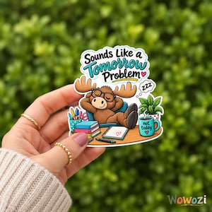 Może przedstawiać: Wykrawana naklejka przedstawiająca brązowego łosia z kreskówki w czarnych okularach, leżącego na krześle z napisem Sounds Like a Tomorrow Problem. Scena zawiera stos książek, długopis, roślinę doniczkową i niebieski kubek z napisem not today.
