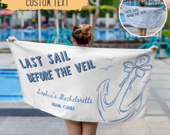 May include: White beach towel with blue text and anchor design. The towel reads "LAST SAIL BEFORE THE VEIL" and "Sophia's Bachelorette, Miami, Florida". The design includes an anchor and several seagulls.