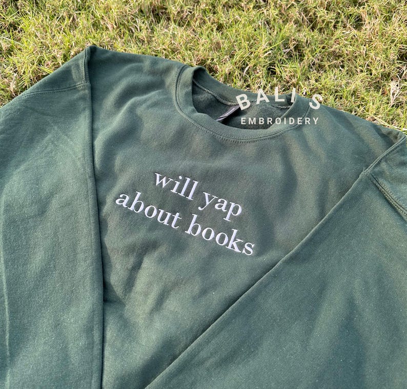 May include: A dark green sweatshirt with the text "will yap about books" embroidered in white on the front.