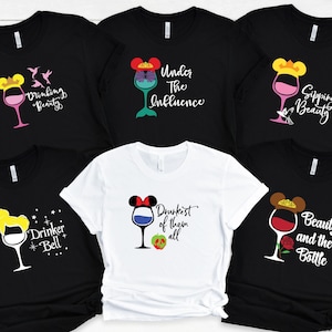 May include: Six black and white t-shirts with a Disney princess theme and wine glass graphics. The shirts feature the text "Drinking Beauty", "Under The Influence", "Sipping Beauty", "Drinker Bell", "Drunkest of them all", and "Beauty and the Bottle".