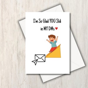 Puede incluir: Una tarjeta de felicitación con una ilustración de dibujos animados de una persona deslizándose por un avión de papel hacia un sobre abierto. El texto de la tarjeta dice "I'm So Glad YOU Slid in MY DMs".