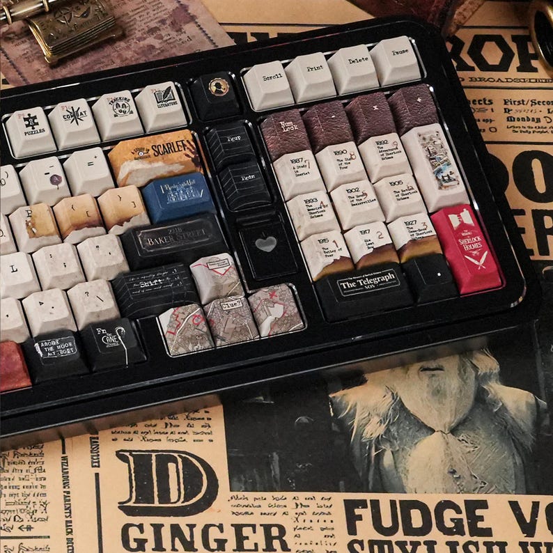 May include: A black mechanical keyboard featuring custom keycaps with Sherlock Holmes-themed designs, including text like 221B Baker Street, The Telegraph, and various book titles. The keys display vintage-style illustrations, maps, and symbols.