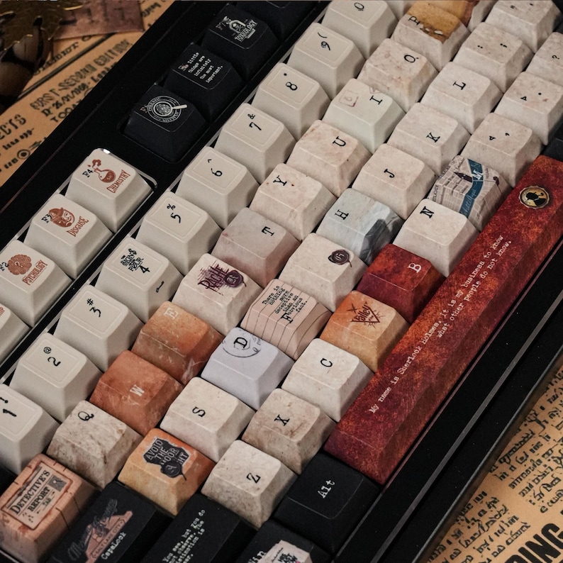 May include: A mechanical keyboard featuring custom keycaps with a vintage aesthetic. The keys display various letters, numbers, and thematic illustrations, including a long spacebar with the text My name is Sherlock Holmes, it is my business to know what other people do not know.