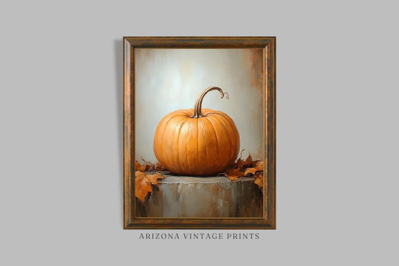 May include: A painting of a single orange pumpkin with a brown stem, sitting on a gray stone surface with brown leaves around it. The painting is framed in a gold frame.