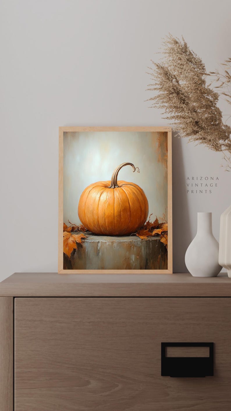 May include: A painting of a single orange pumpkin on a gray surface with brown leaves. The pumpkin has a brown stem and is sitting on a table. The background is a light gray color.
