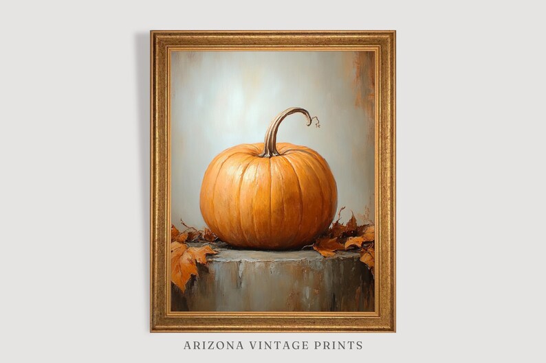 May include: A painting of a single orange pumpkin with a brown stem, sitting on a gray surface with brown leaves scattered around it. The painting is framed in a gold frame.