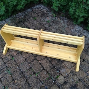 Può includere: Un supporto in legno con più fori per riporre strumenti o altri oggetti. Il supporto è in legno chiaro e ha un design semplice.