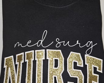 Sudadera negra de enfermera con purpurina dorada